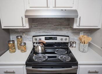 a small kitchen with a stove and a kettle on it